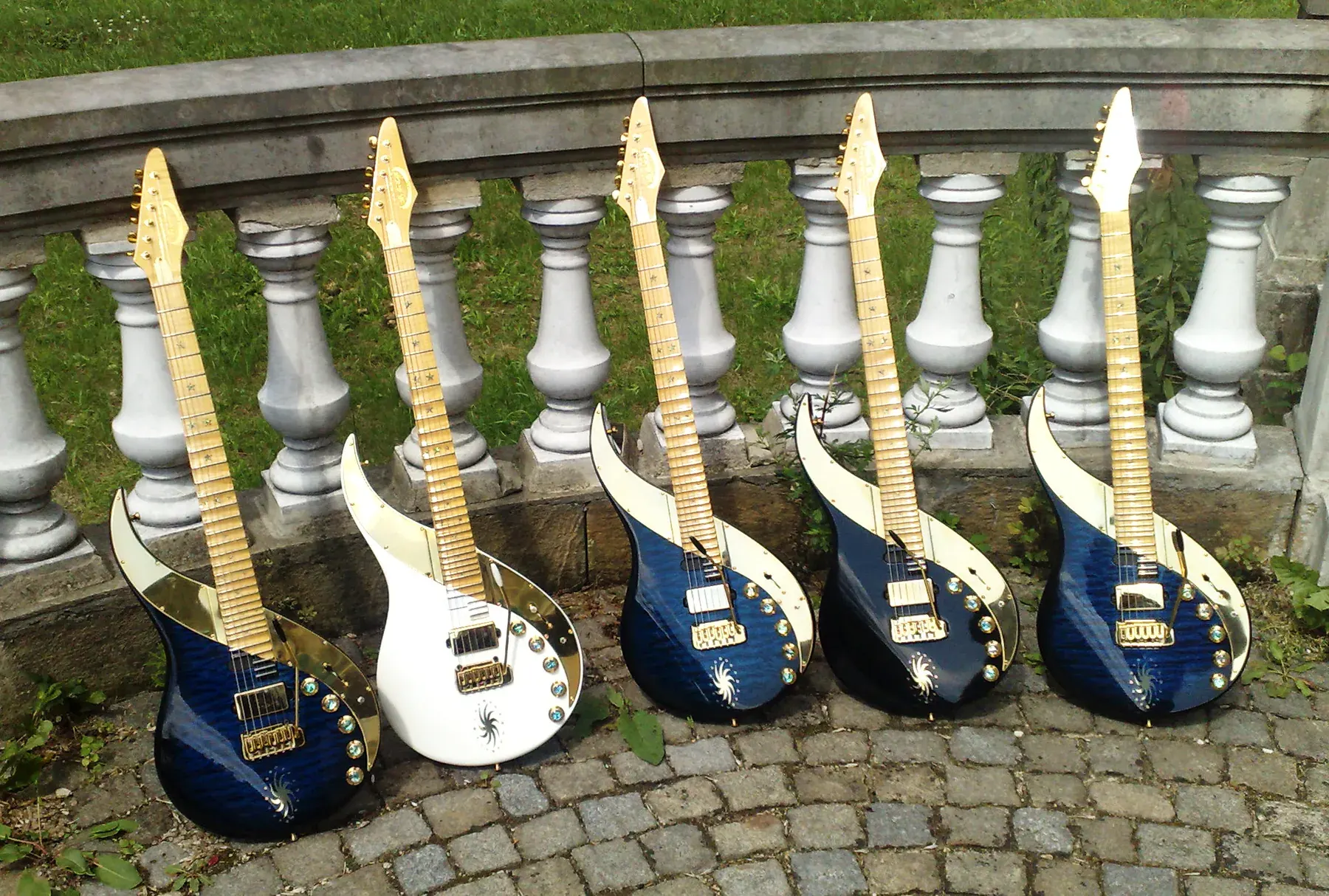 Cinco Sky Guitars en azul y blanco apoyadas en una balaustrada de piedra, en julio de 2011