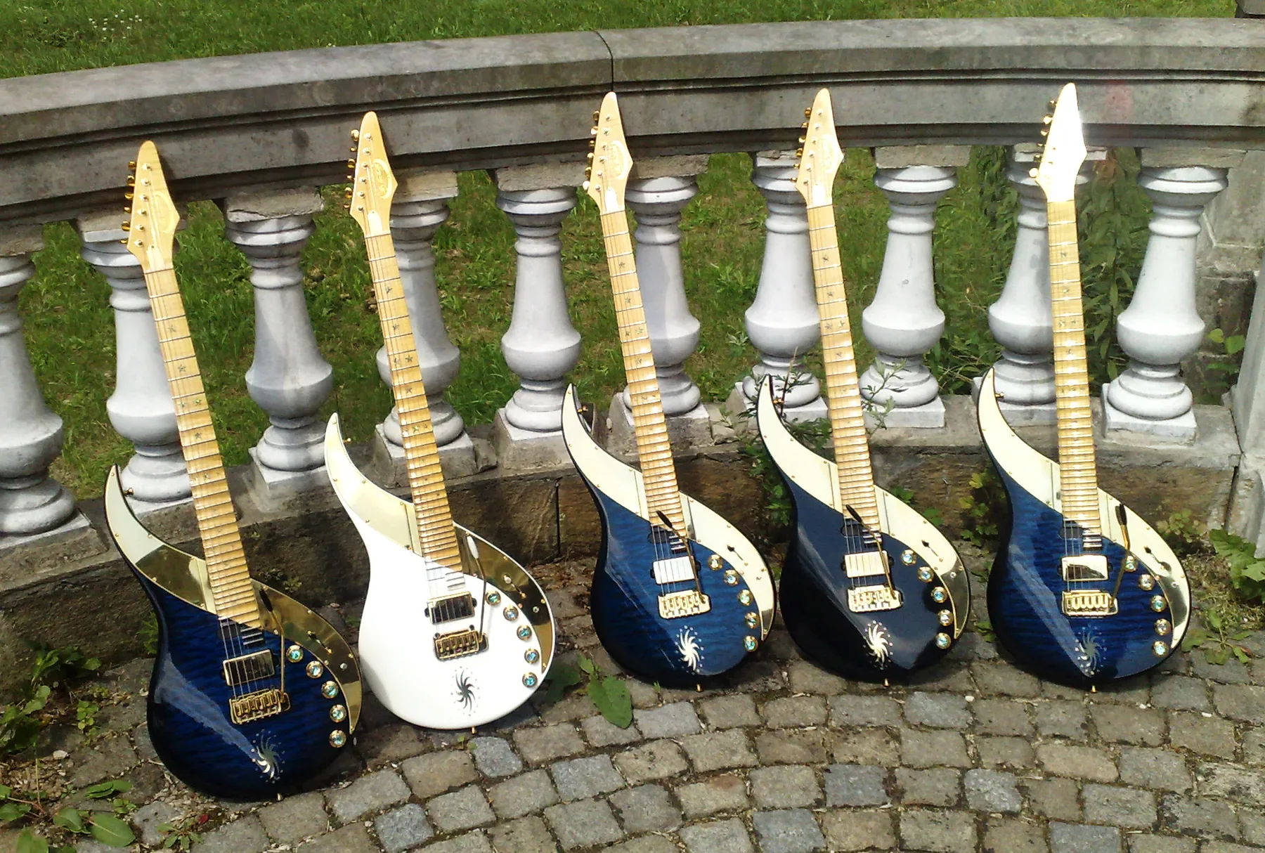 Cinco Sky Guitars en azul y blanco apoyadas en una balaustrada de piedra, en julio de 2011