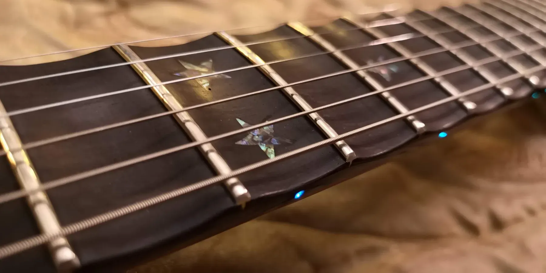 Diapasón oscuro de la Mahogany Queen con estrellas de nácar y LED azules en el canto