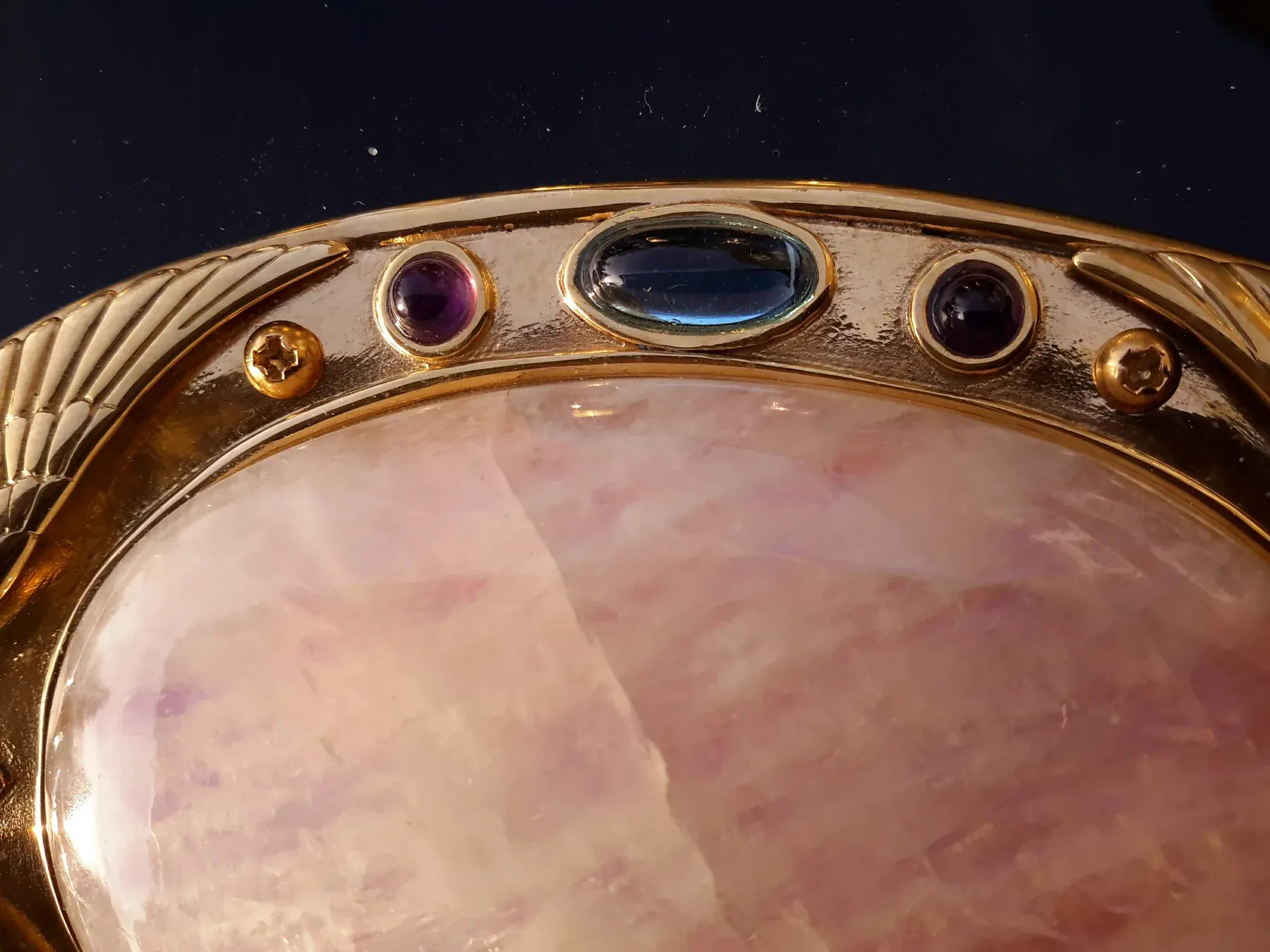 Primer plano de la gran piedra de luna de la Excalibur, engastada en oro con gemas de colores