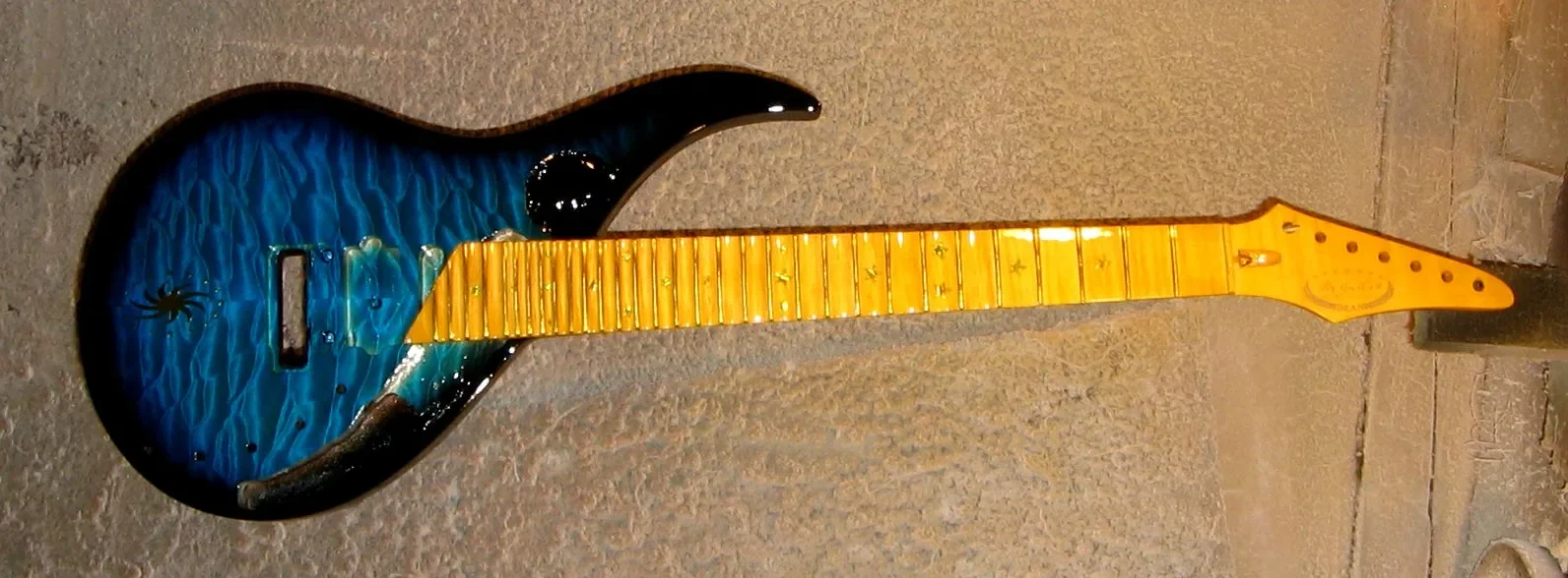 Sky Guitar azul con degradado a negro, mástil de arce y herrajes dorados, fotografiada entera