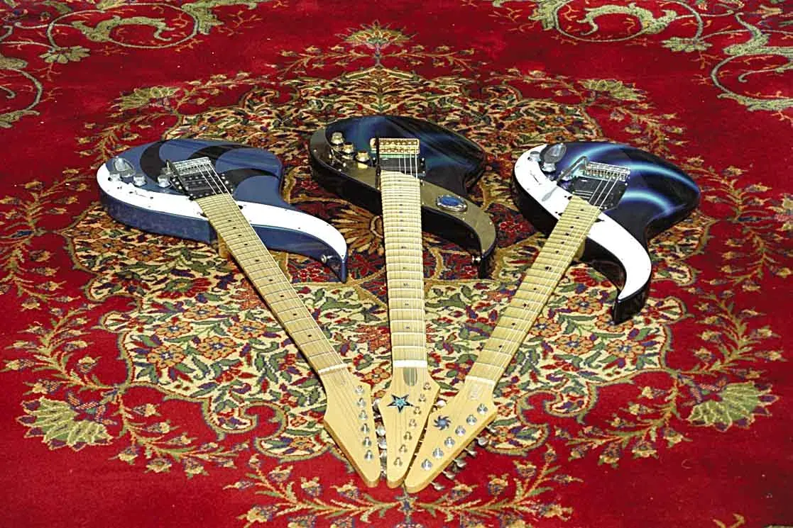 Tres Sky Guitars azules y blancas en abanico sobre una alfombra persa roja