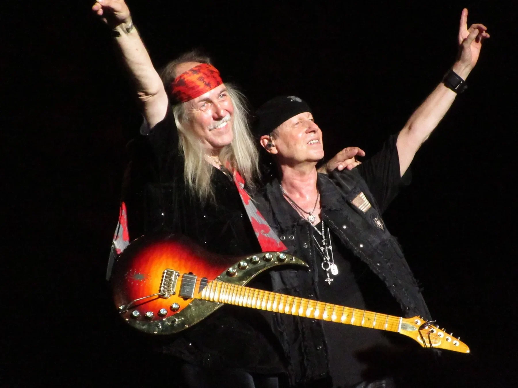 Uli Jon Roth levanta los brazos junto a otro músico en el Saitama Super Arena, con una Sky Elite colgada