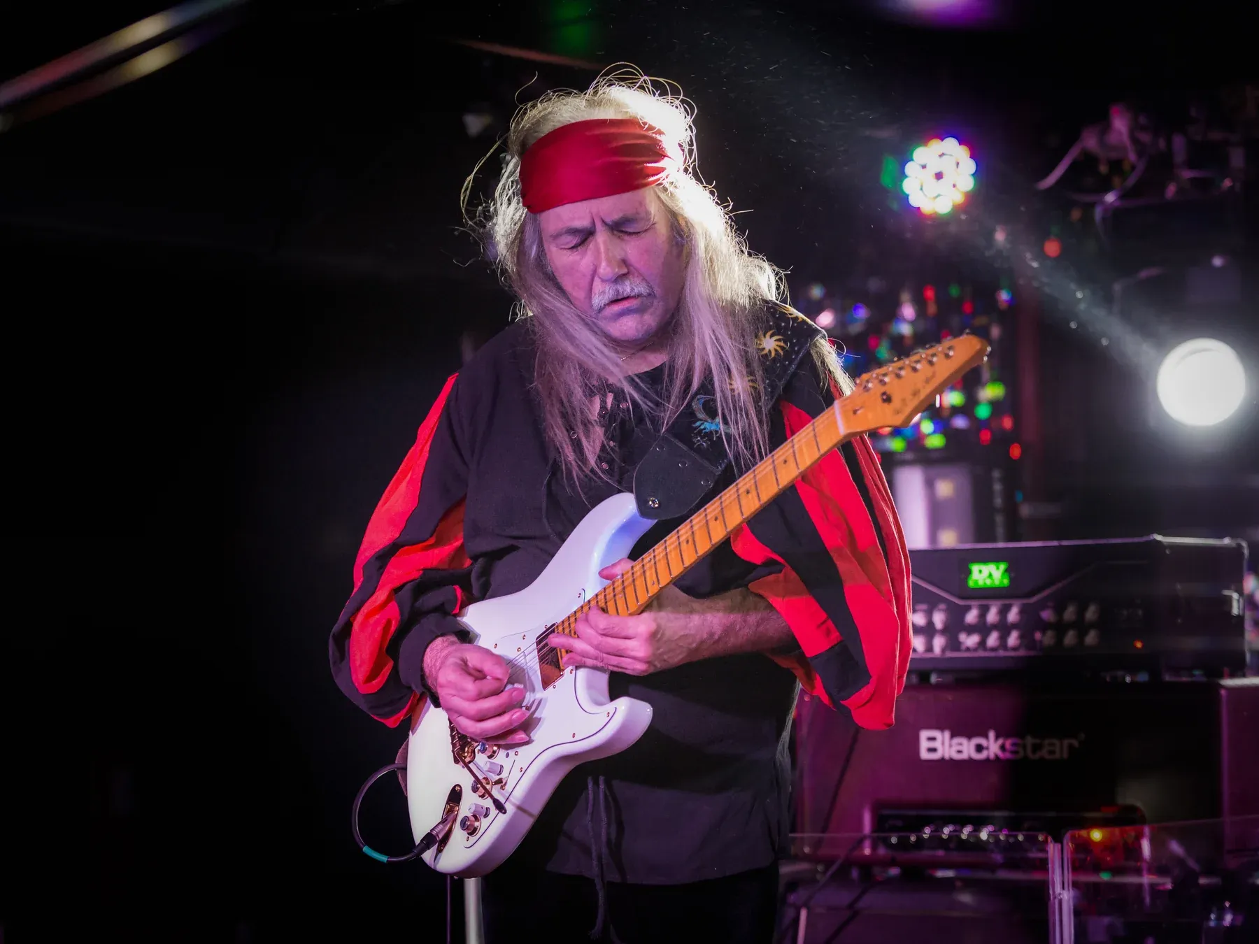 Uli Jon Roth en concierto con la Sky Super Strat blanca y su pañuelo rojo