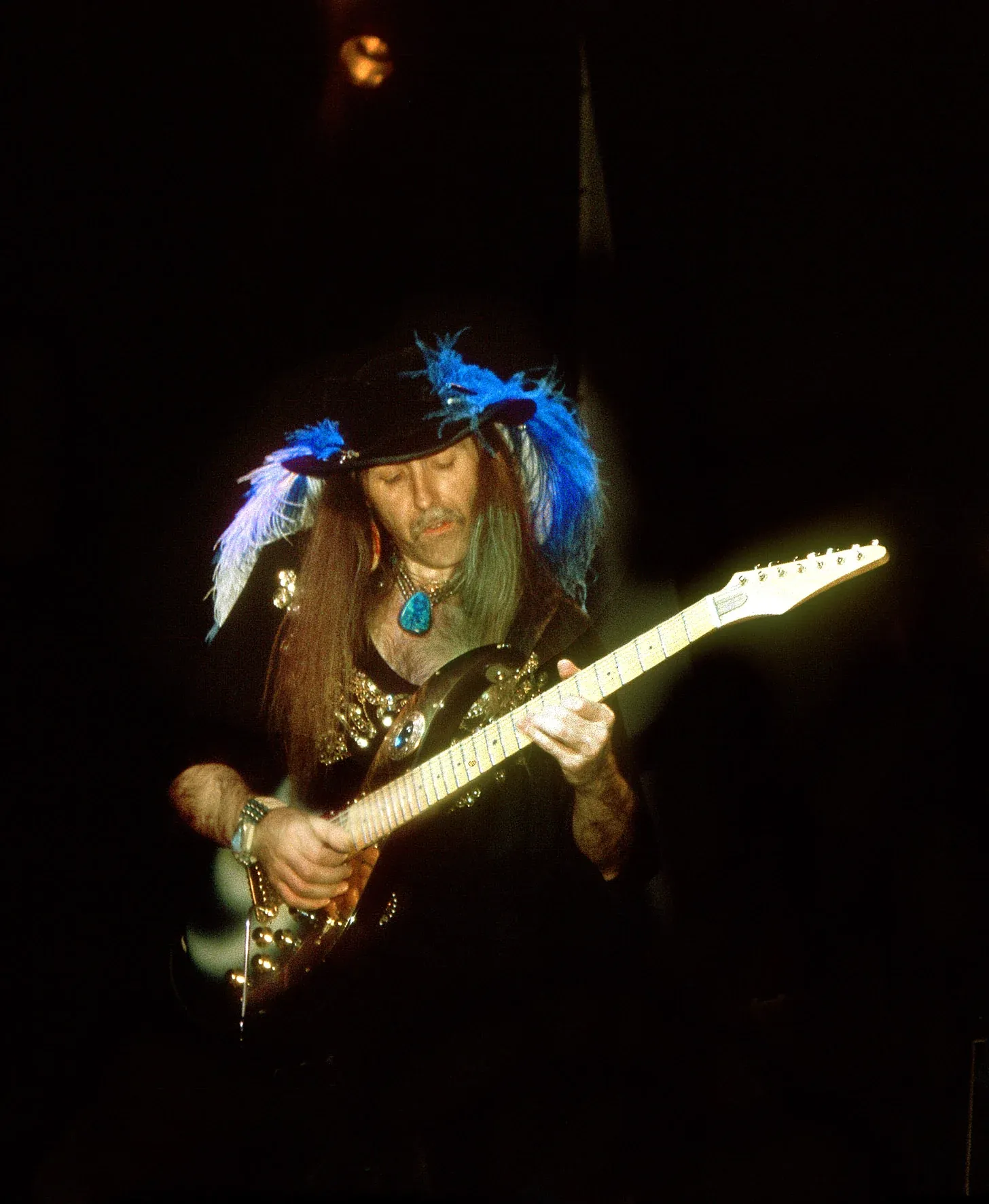 Uli Jon Roth en directo, con plumas azules en el sombrero y una Sky Guitar